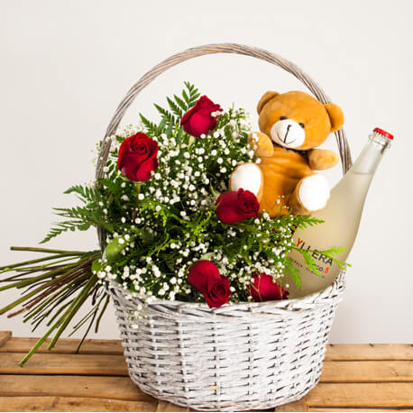Cesta con rosas, botella de vino y un peluche para regalar. regalo de flores a domicilio y sin gastos de envío en Madrid.