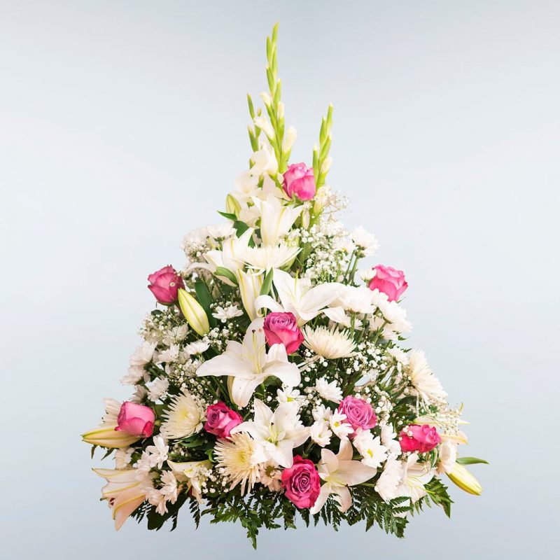 Centro de flores para funeral en tonos rosa.